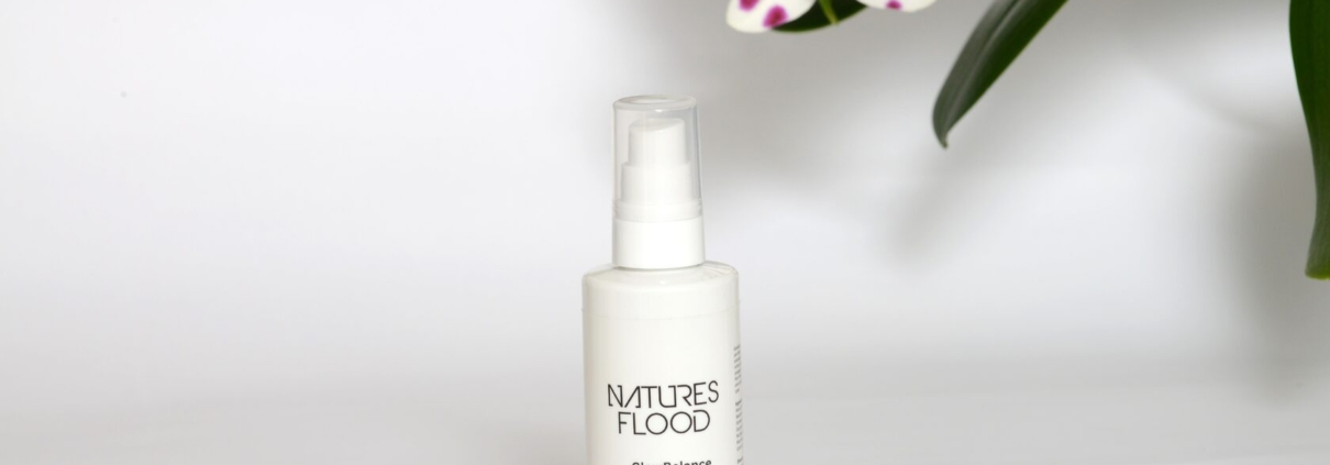 Natures Flood GlowBalance Niacinamide Face Cleanser beside orchid flowers