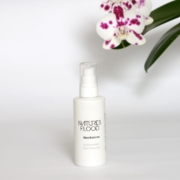 Natures Flood GlowBalance Niacinamide Face Cleanser beside orchid flowers